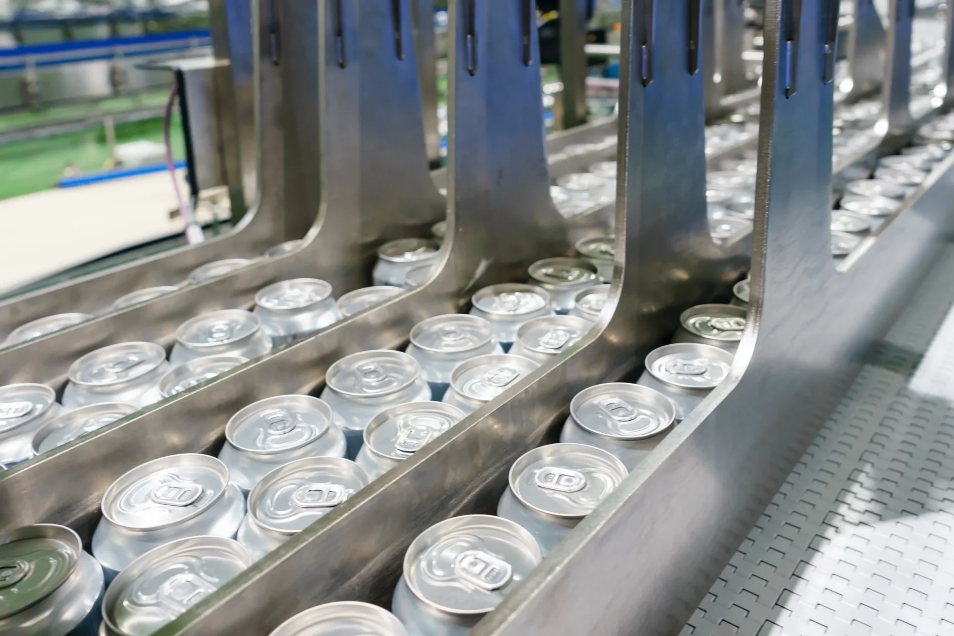 Aluminum cans on a high-speed conveyor lane between filling and packaging equipment